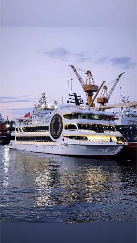 Custom-Craft Restaurant and Excursion vessel Modern Custom-Craft restaurant vessel docked, 2025 model, illuminated at dusk.
