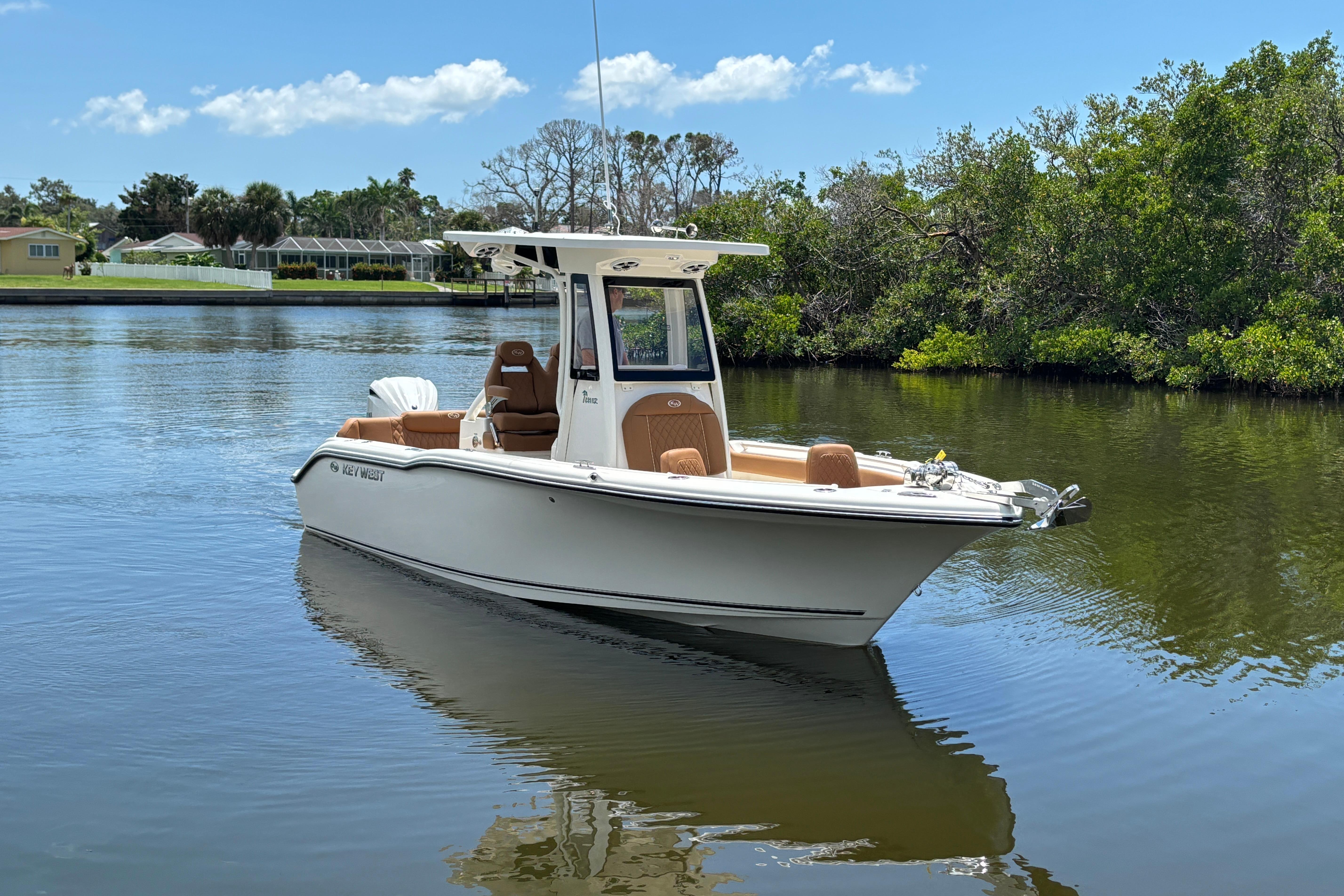 Key West 239 FSR 2026 Key West 239 FSR boat on calm water, surrounded by lush greenery.