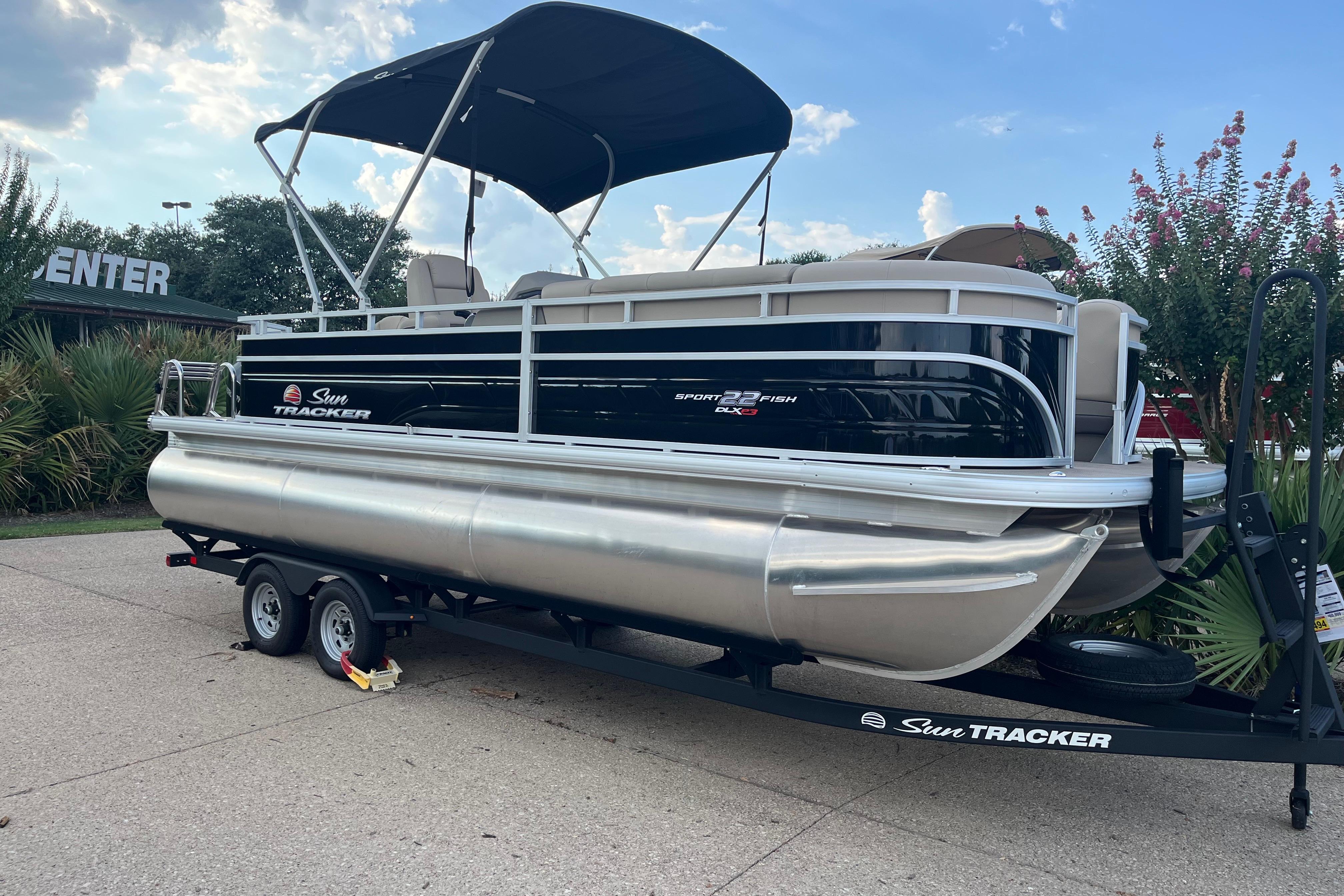 Sun Tracker SportFish 22 XP3 2025 Sun Tracker SportFish 22 XP3 pontoon boat on trailer, parked outdoors.