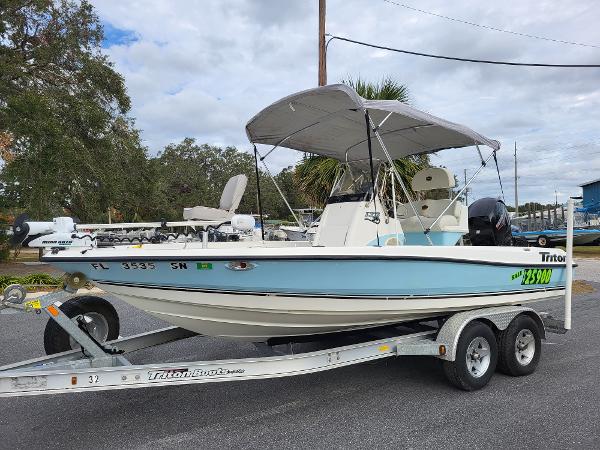 Triton 190 LTS 2006 Triton 190 LTS boat on trailer with canopy, parked outdoors.