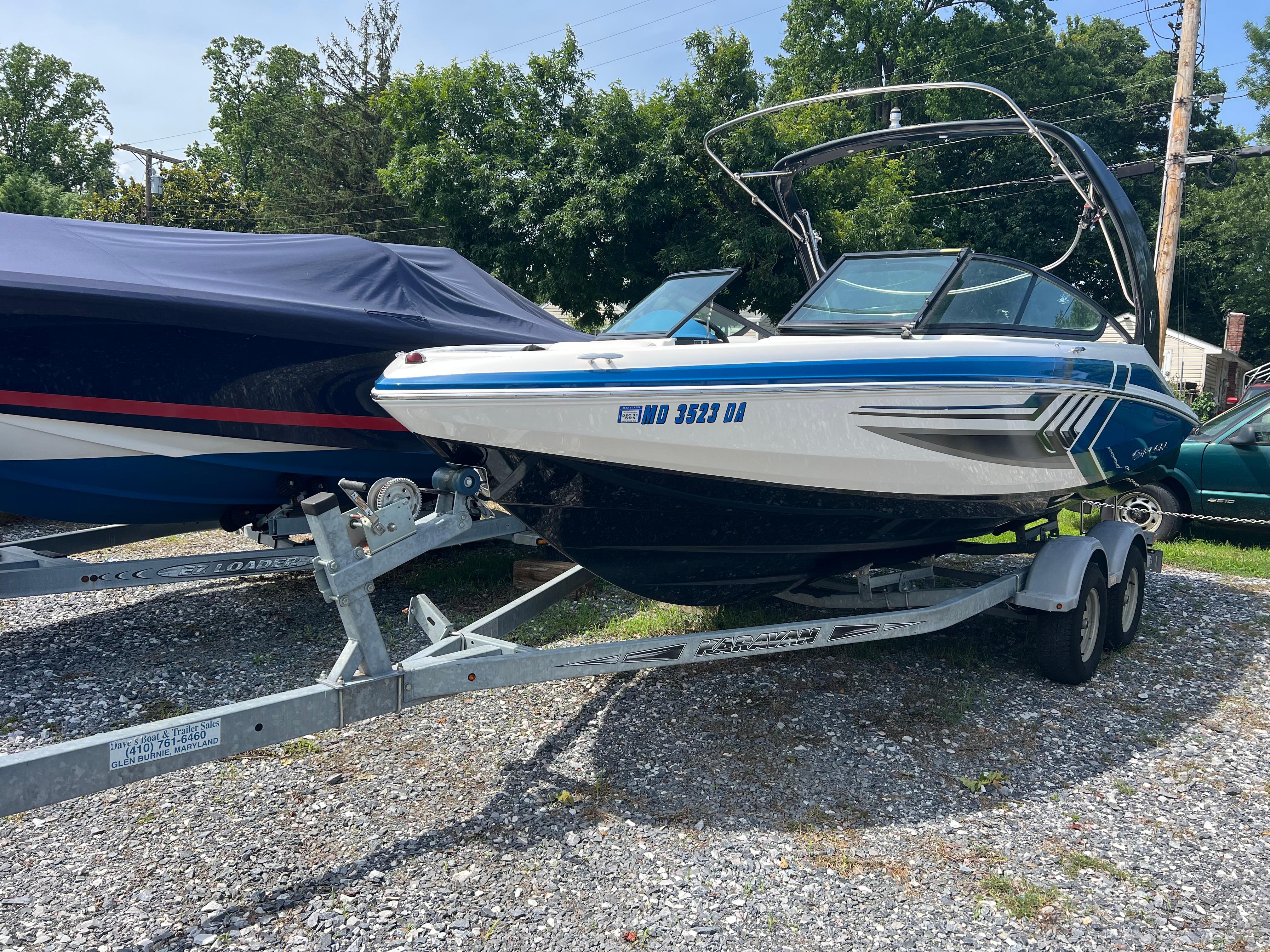 Regal 2000 ESX Bowrider 2016 Regal 2000 ESX Bowrider on trailer, parked outdoors, surrounded by trees and other boats.