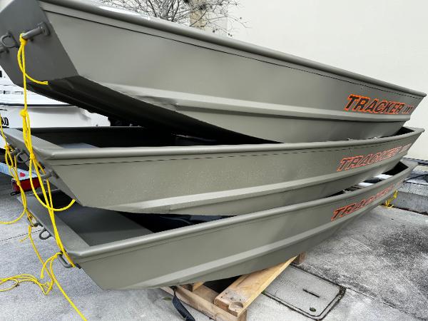 Tracker Grizzly 1036 Utility Stacked 2025 Tracker Grizzly 1036 Utility boats with yellow ropes, ready for transport.