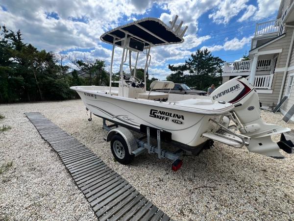 Carolina Skiff 178 DLV 2019 Carolina Skiff 178 DLV boat on trailer with Evinrude motor in driveway.