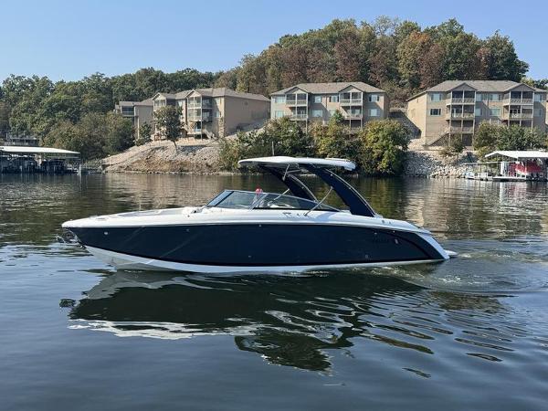 Cobalt R30 2025 Cobalt R30 boat cruising on a lake with waterfront homes in the background.