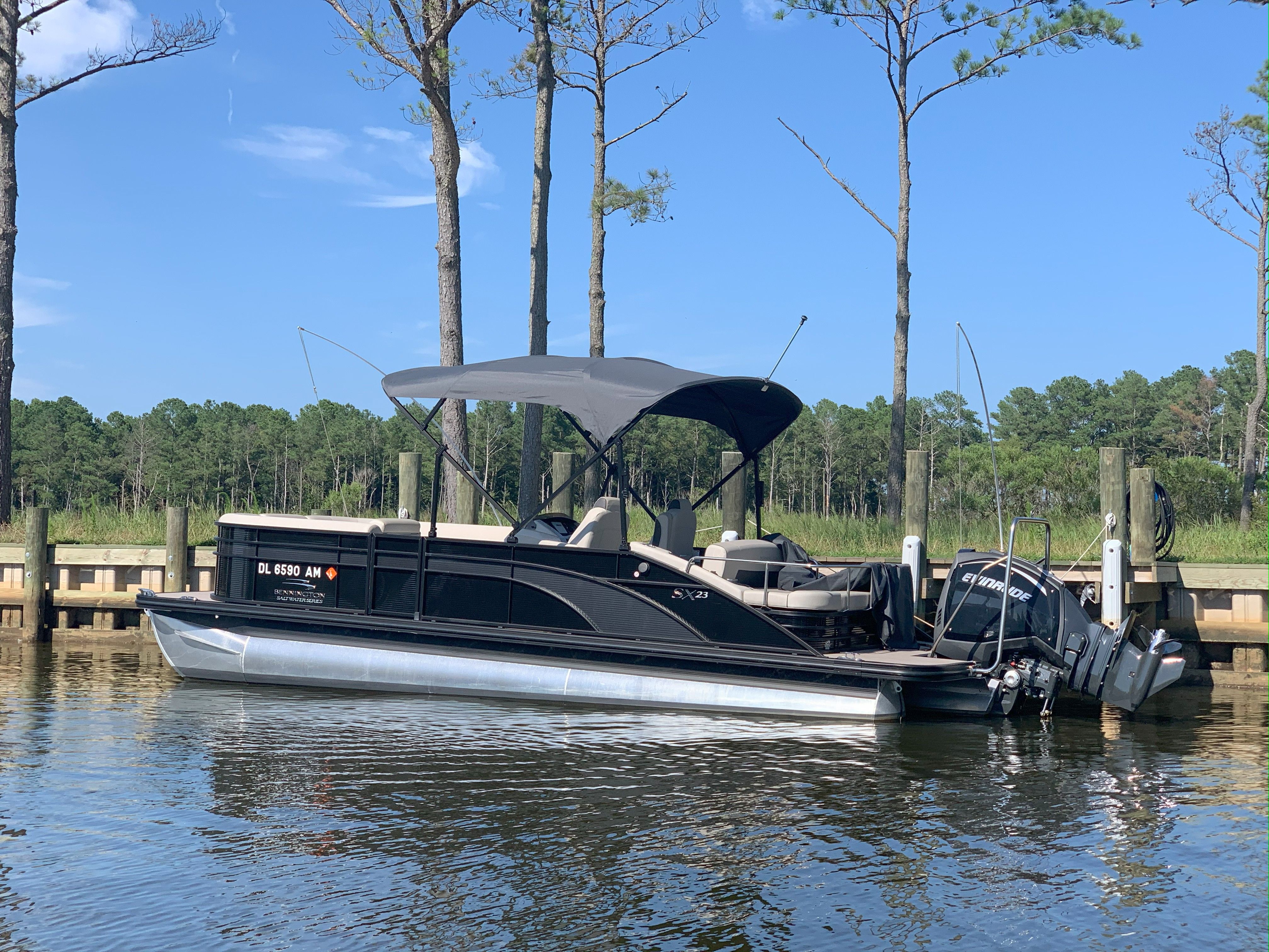 Bennington 23ssb 2019 Bennington 23ssb pontoon boat docked on a sunny day with trees in the background.