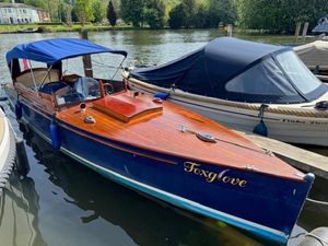 Classic Slipper Launch Classic 1925 Slipper Launch boat named "Foxglove" docked on a serene river.