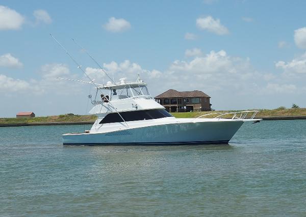 Viking Convertible 2001 Viking Convertible yacht on calm water under a clear blue sky.
