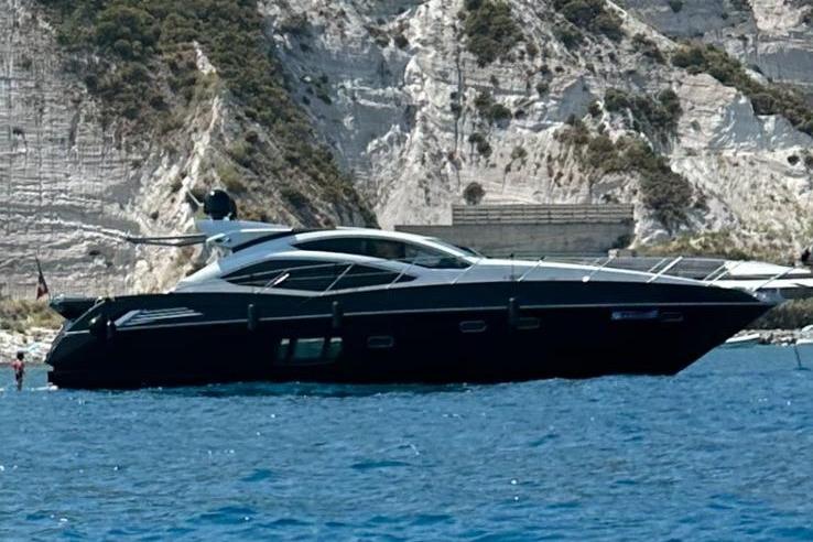 Sunseeker Predator 64 2009 Sunseeker Predator 64 yacht cruising near rocky cliffs.