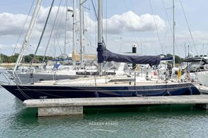 Oyster 37 1978 Oyster 37 sailboat docked at marina, featuring sleek design and covered mainsail.