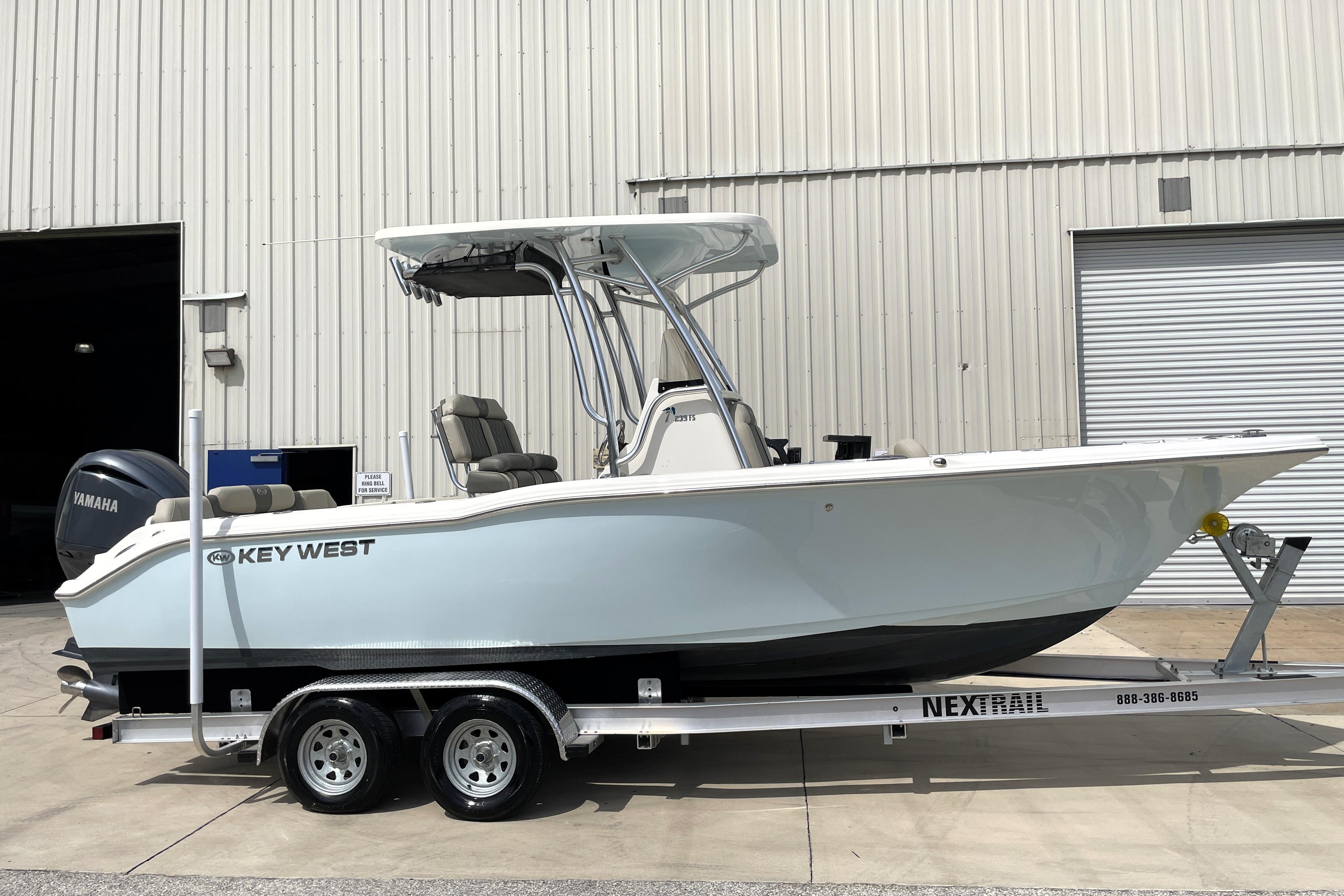Key West 239 FS 2024 Key West 239 FS boat on trailer, parked outside a warehouse.