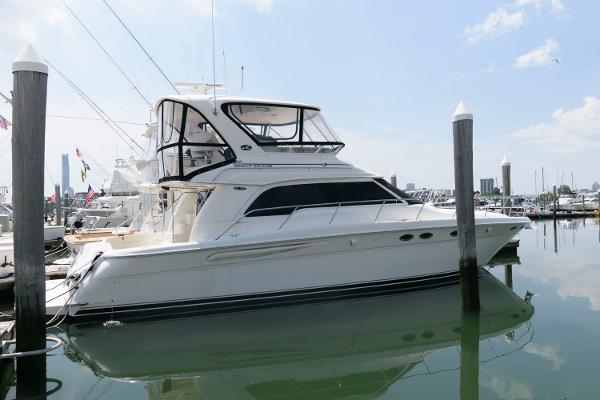 Sea Ray 480 Sedan Bridge 2004 Sea Ray 480 Sedan Bridge yacht docked in a marina, reflecting on calm water.