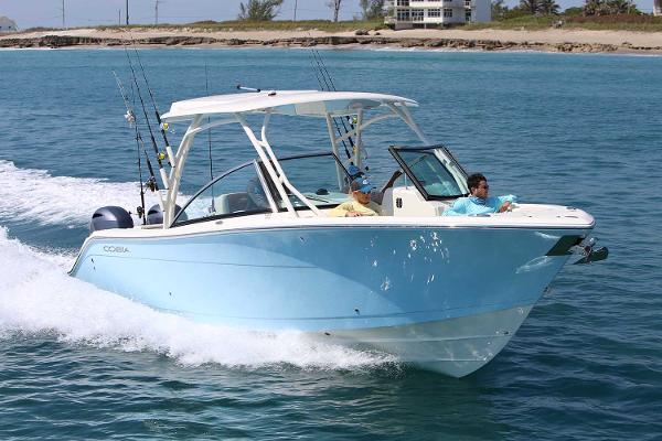 Cobia 280 Dual Console 2025 Cobia 280 Dual Console boat cruising on clear blue water.