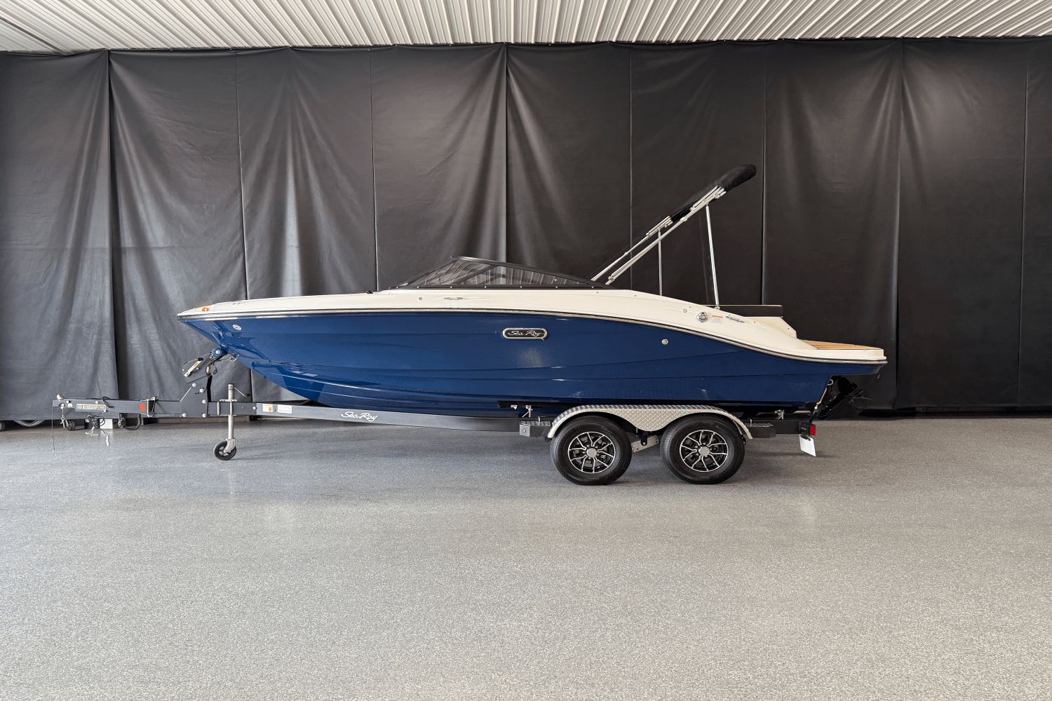 Sea Ray SPX 190 2025 Sea Ray SPX 190 boat on trailer in indoor showroom.