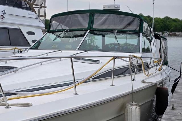 Sea Ray 390 Express Cruiser 1986 Sea Ray 390 Express Cruiser docked, featuring sleek design and green canopy.