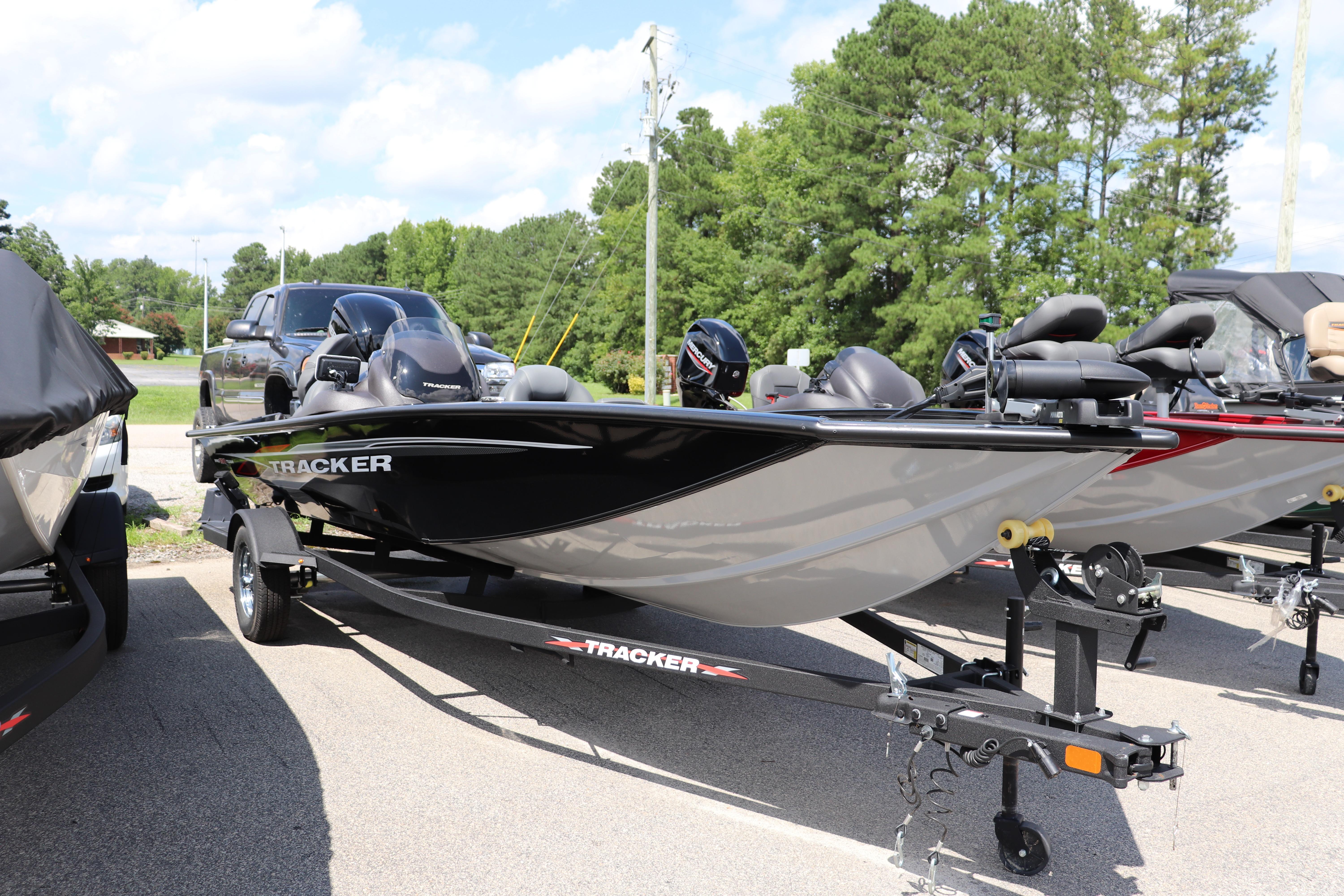 Tracker Pro Team 190 TX 2024 Tracker Pro Team 190 TX boat on trailer, parked outdoors with trees in background.