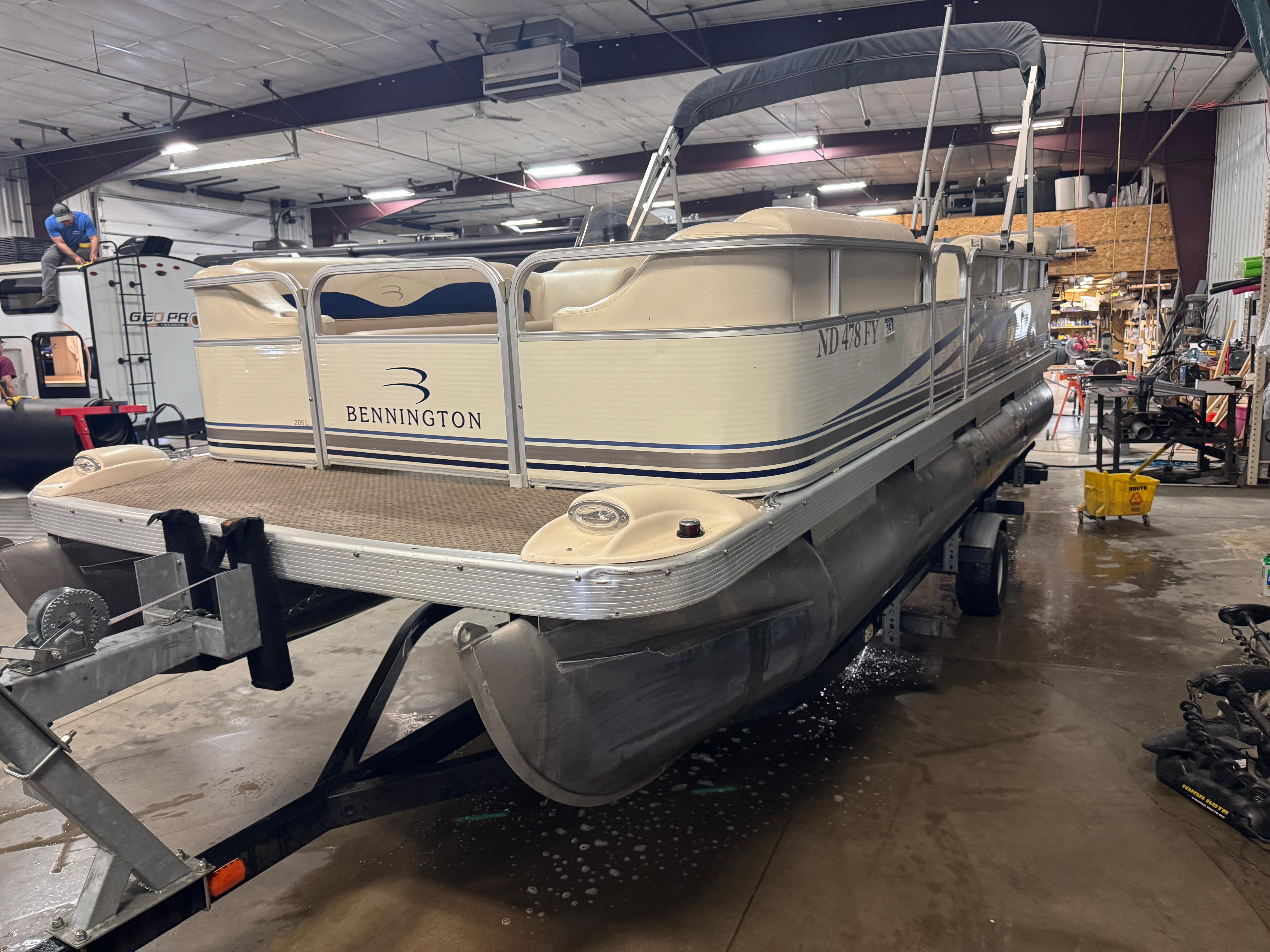 Bennington 205L 2003 Bennington 205L pontoon boat on trailer in a workshop setting.