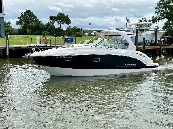 Chaparral 330 Signature 2015 Chaparral 330 Signature boat cruising on a calm waterway near a dock.