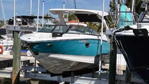 Regal LX6 2022 Regal LX6 boat docked at marina, featuring sleek design and vibrant teal color.