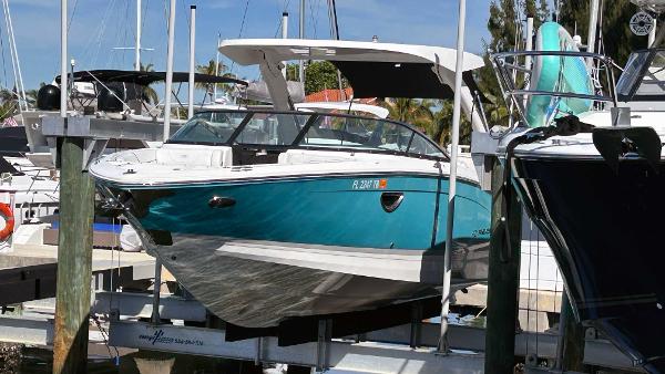 Regal LX6 2022 Regal LX6 boat docked at marina, featuring sleek design and vibrant teal color.