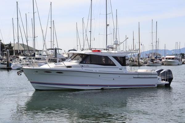 Cutwater C-302 Coupe 2018 Cutwater C-302 Coupe boat docked in a marina with sailboats.
