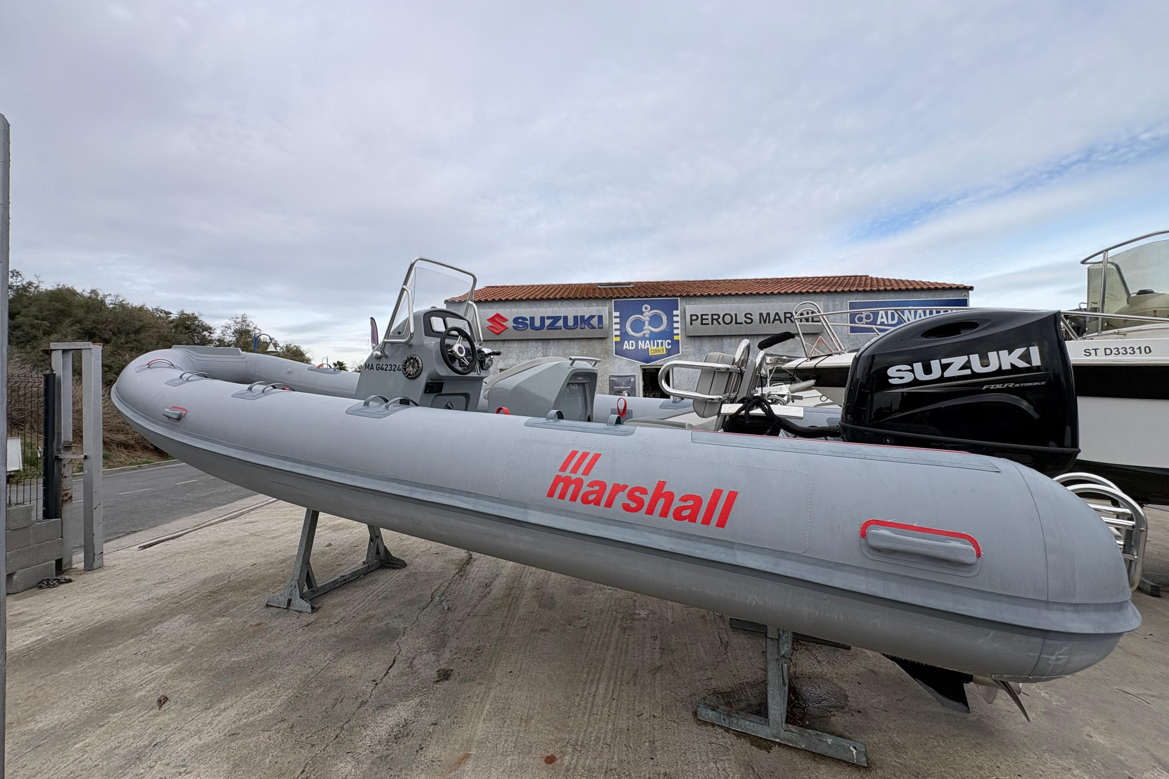 Marshall M4 TORUING 2022 Marshall M4 Touring boat with Suzuki engine displayed at a marine dealership.