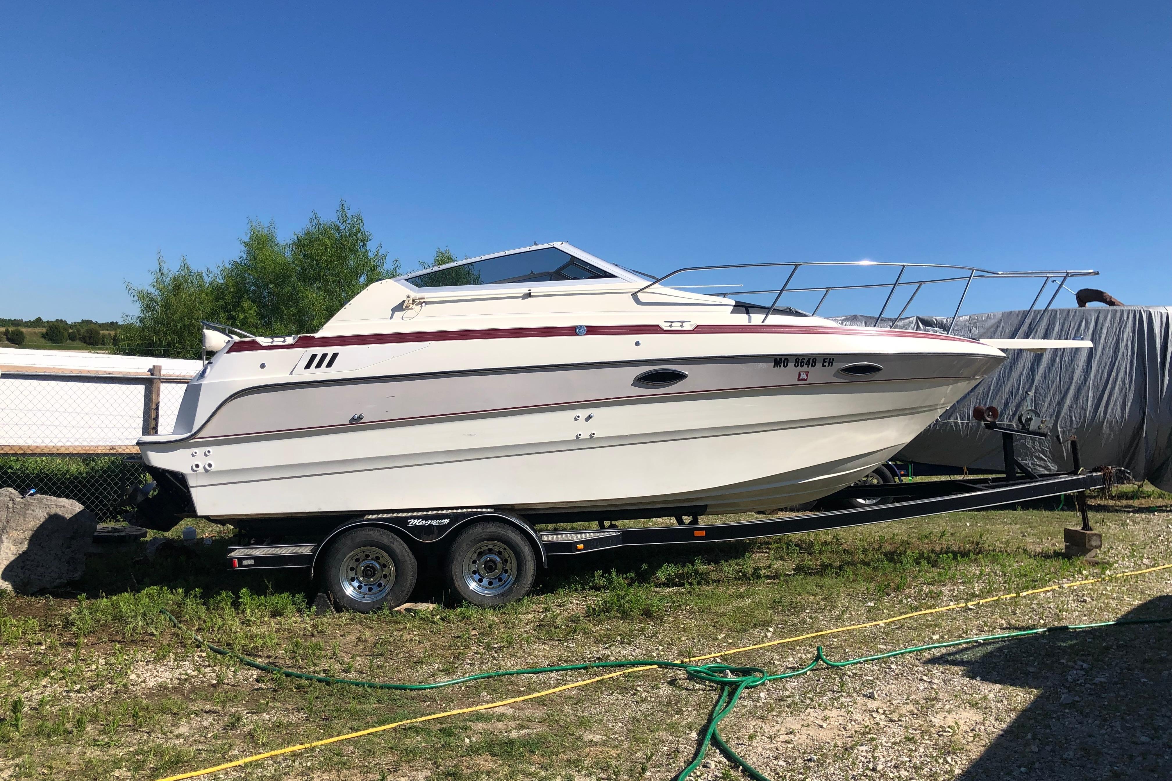 Maxum 2300 SC 1992 Maxum 2300 SC boat on trailer, parked outdoors under clear blue sky.