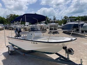 Boston Whaler 170 Montauk 2005 Boston Whaler 170 Montauk boat with blue canopy on trailer, parked outdoors.