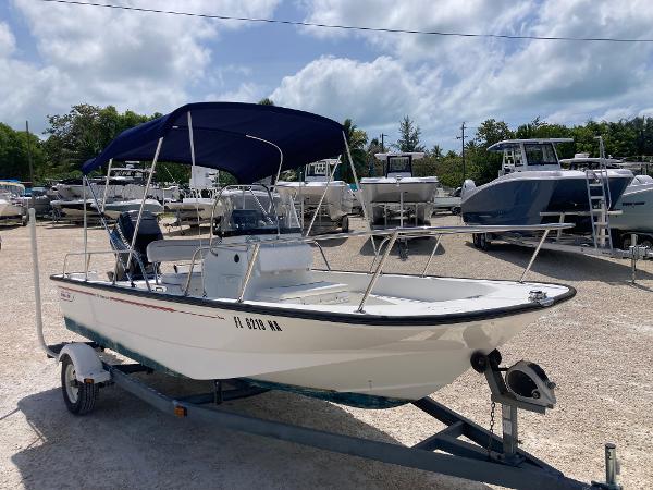 Boston Whaler 170 Montauk 2005 Boston Whaler 170 Montauk boat with blue canopy on trailer, parked outdoors.