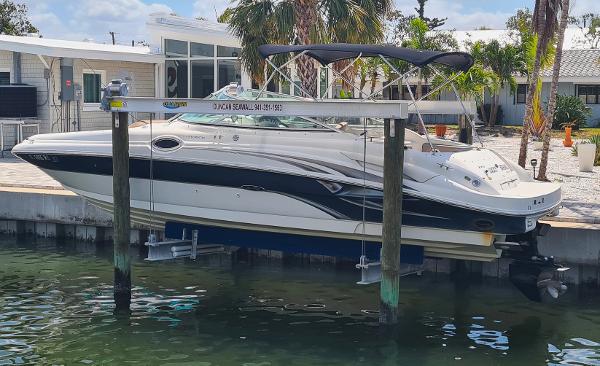 Sea Ray 270 Sundeck 2004 Sea Ray 270 Sundeck boat docked on a lift by waterfront property.