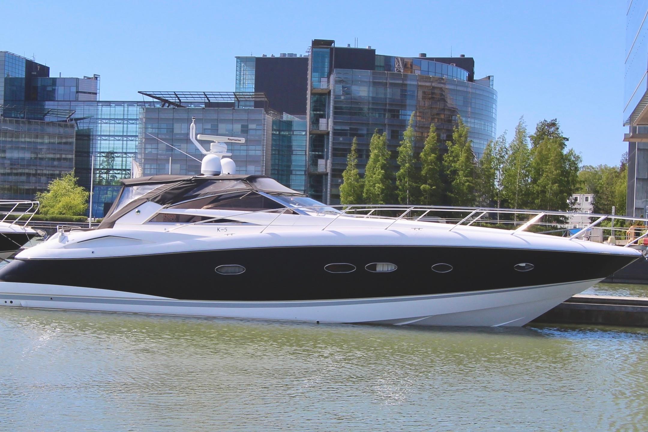 Sunseeker Portofino 53 Luxury 2006 Sunseeker Portofino 53 yacht docked near modern buildings.