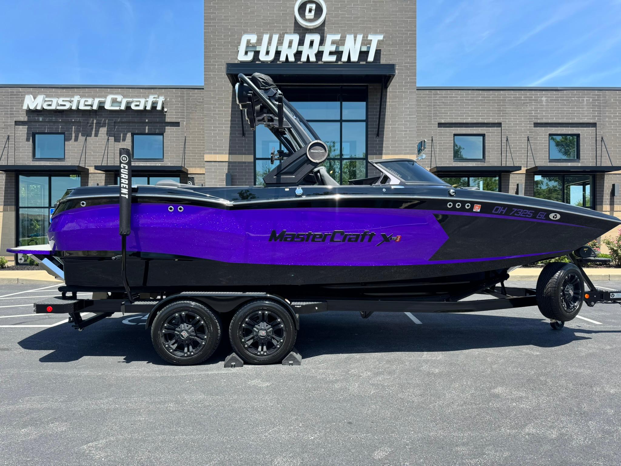 MasterCraft XStar S Piranha 2023 MasterCraft XStar S Piranha boat in vibrant purple, parked outside dealership.