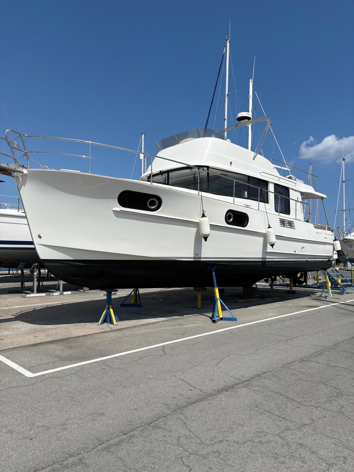 Beneteau Swift Trawler 44 2017 Beneteau Swift Trawler 44 on stands in a marina under clear blue sky.