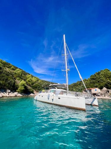 Fountaine Pajot LAVEZZI 40 2005 Fountaine Pajot LAVEZZI 40 catamaran in clear turquoise water, surrounded by lush greenery.