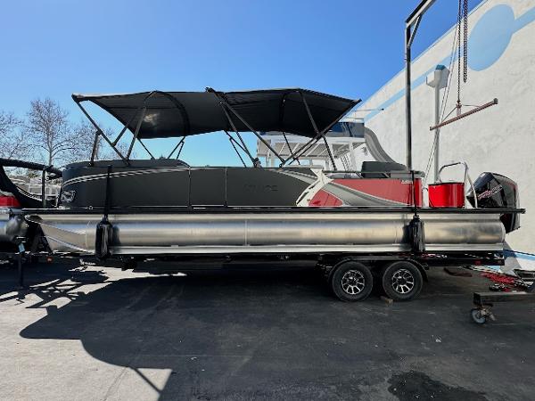Tahoe Pontoon 2585 LTZ Entertainer 2025 Tahoe Pontoon 2585 LTZ Entertainer boat on trailer, black canopy, outdoor setting.