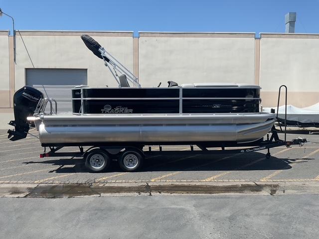 Sun Tracker Party Barge 20 DLX 2026 Sun Tracker Party Barge 20 DLX pontoon boat on trailer, parked outdoors.