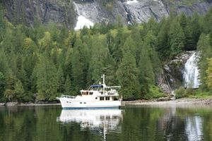 Selene Ocean Trawler 43 Selene Ocean Trawler 43 (2001) anchored near a forested waterfall, reflecting on calm water.