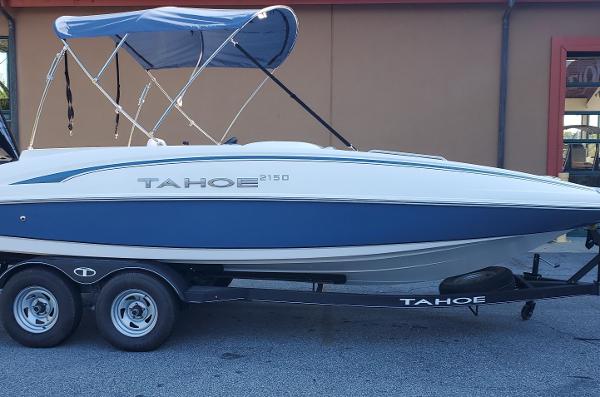 Tahoe 2150 2024 Tahoe 2150 boat with blue canopy on trailer, side view.