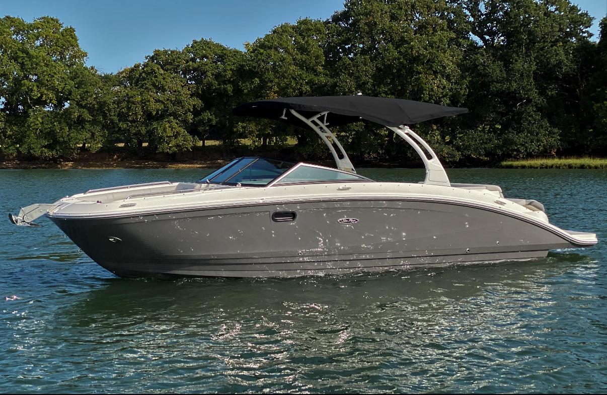 Sea Ray SDX 270 2023 Sea Ray SDX 270 boat on a calm lake with trees in the background.