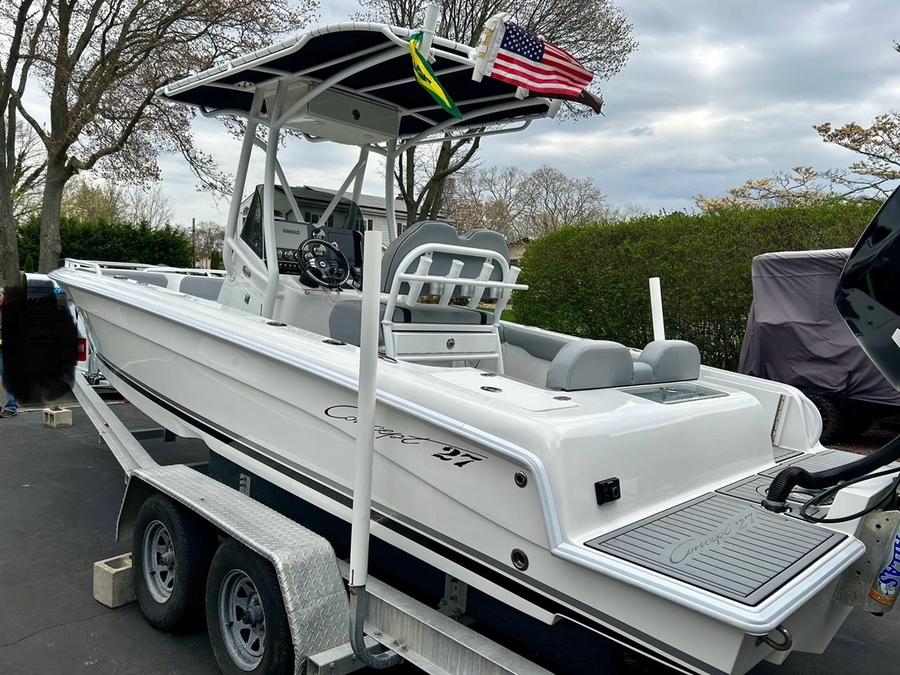 Concept 27 2018 Concept 27 boat on trailer with American flag, parked outdoors.