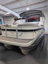 Bennington 22SSR 2024 Bennington 22SSR pontoon boat in showroom, featuring sleek design and canopy.