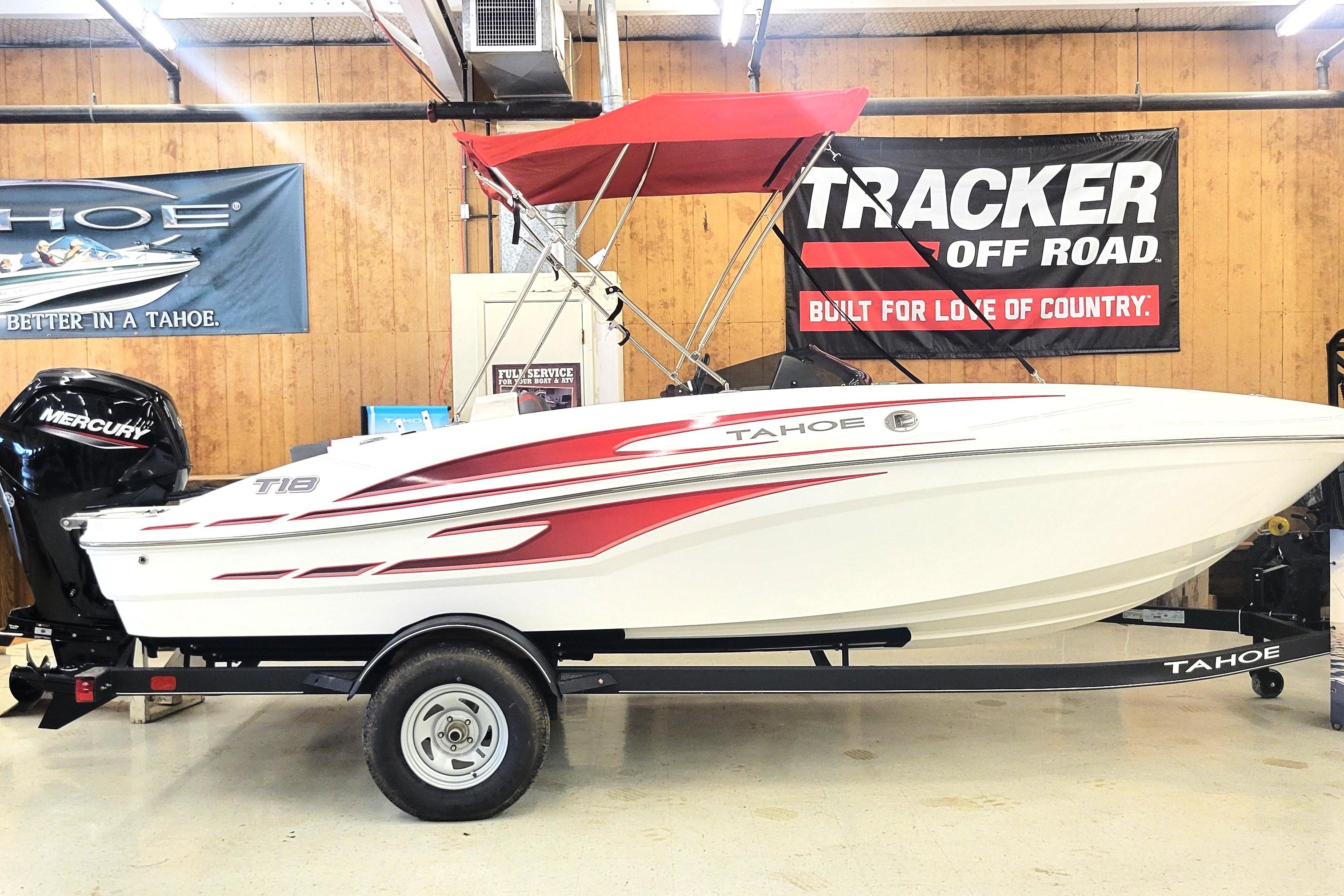 Tahoe T18 2024 Tahoe T18 boat with red accents and Mercury engine in showroom.