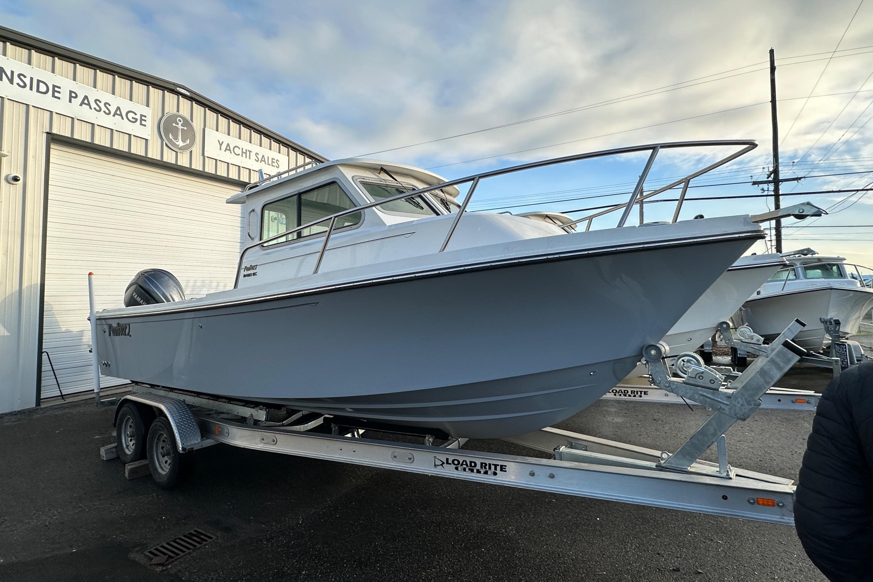 Parker 2420 Sport Cabin 2025 Parker 2420 Sport Cabin boat on trailer at yacht sales dealership.