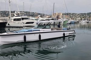 Axopar 37 SUN TOP BRABUS 2023 Axopar 37 Sun Top boat docked in a marina with other yachts.