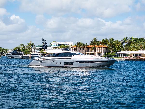 Azimut S8 2024 Azimut S8 yacht cruising on a sunny day near luxury waterfront homes.