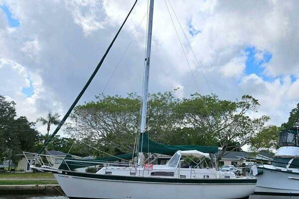 Irwin Mark IV 37 1980 Irwin Mark IV 37 sailboat docked, with green canopy and mast, under cloudy sky.