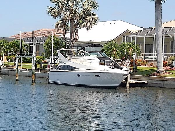 Carver 36 Mariner 2005 Carver 36 Mariner yacht docked by waterfront homes, surrounded by palm trees.