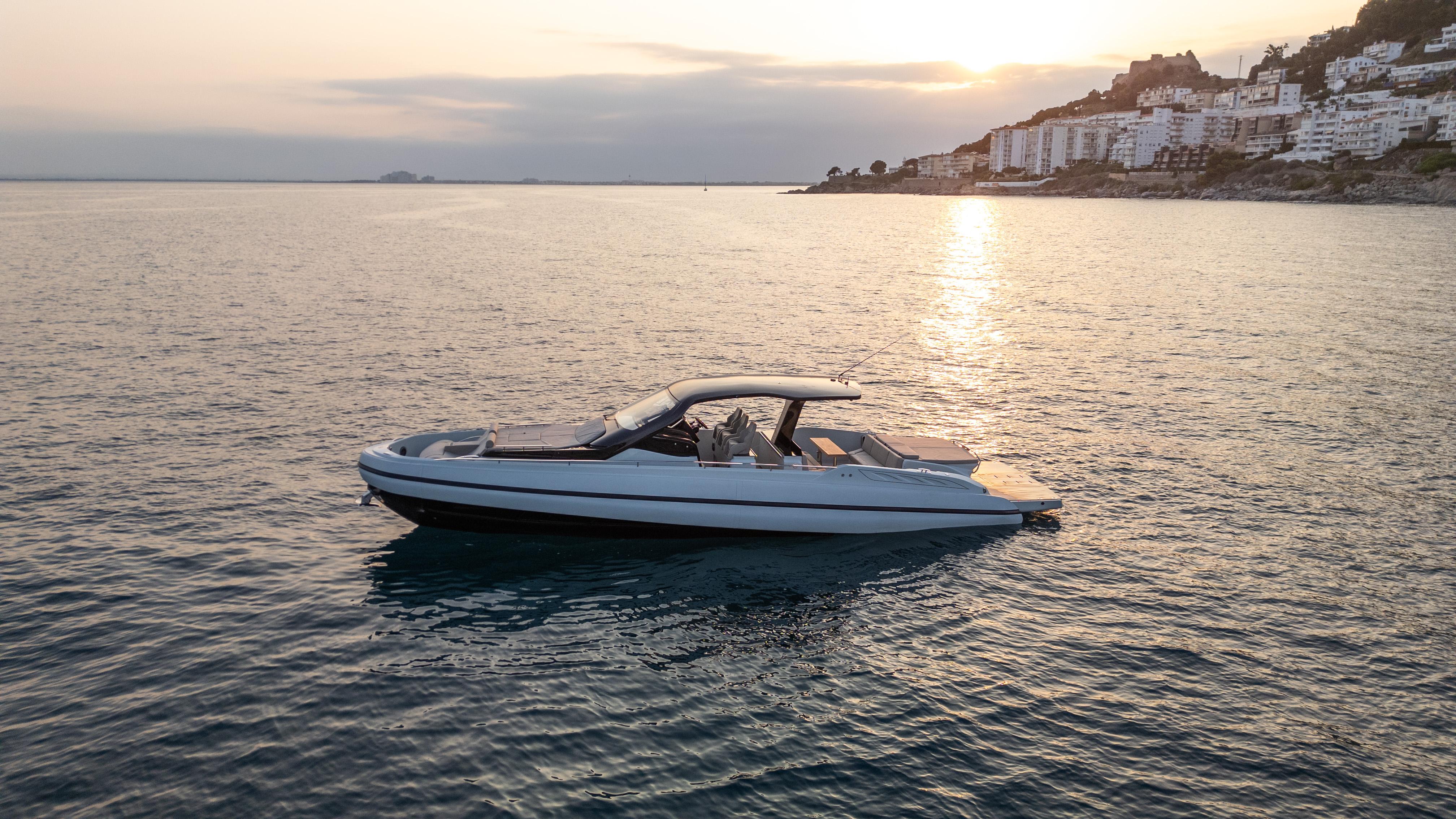 SACS Rebel 47 2025 SACS Rebel 47 yacht cruising at sunset near coastal cityscape.