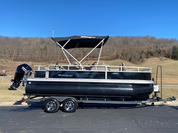 Ranger Reata 200F 2024 Ranger Reata 200F pontoon boat on trailer, parked outdoors under clear blue sky.