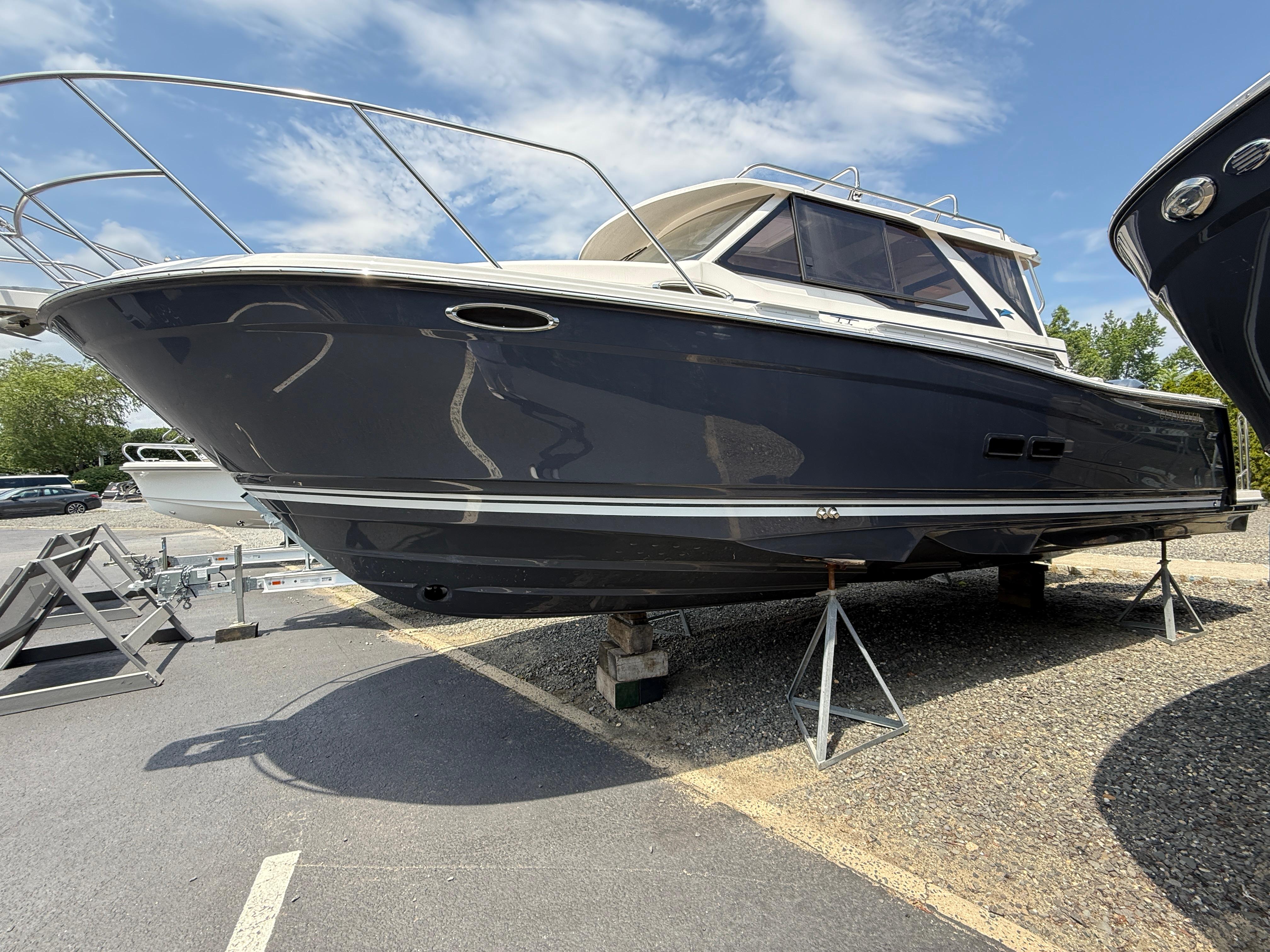 Cutwater C-288 Coupe LE 2025 Cutwater C-288 Coupe LE boat on stands, under a clear blue sky.