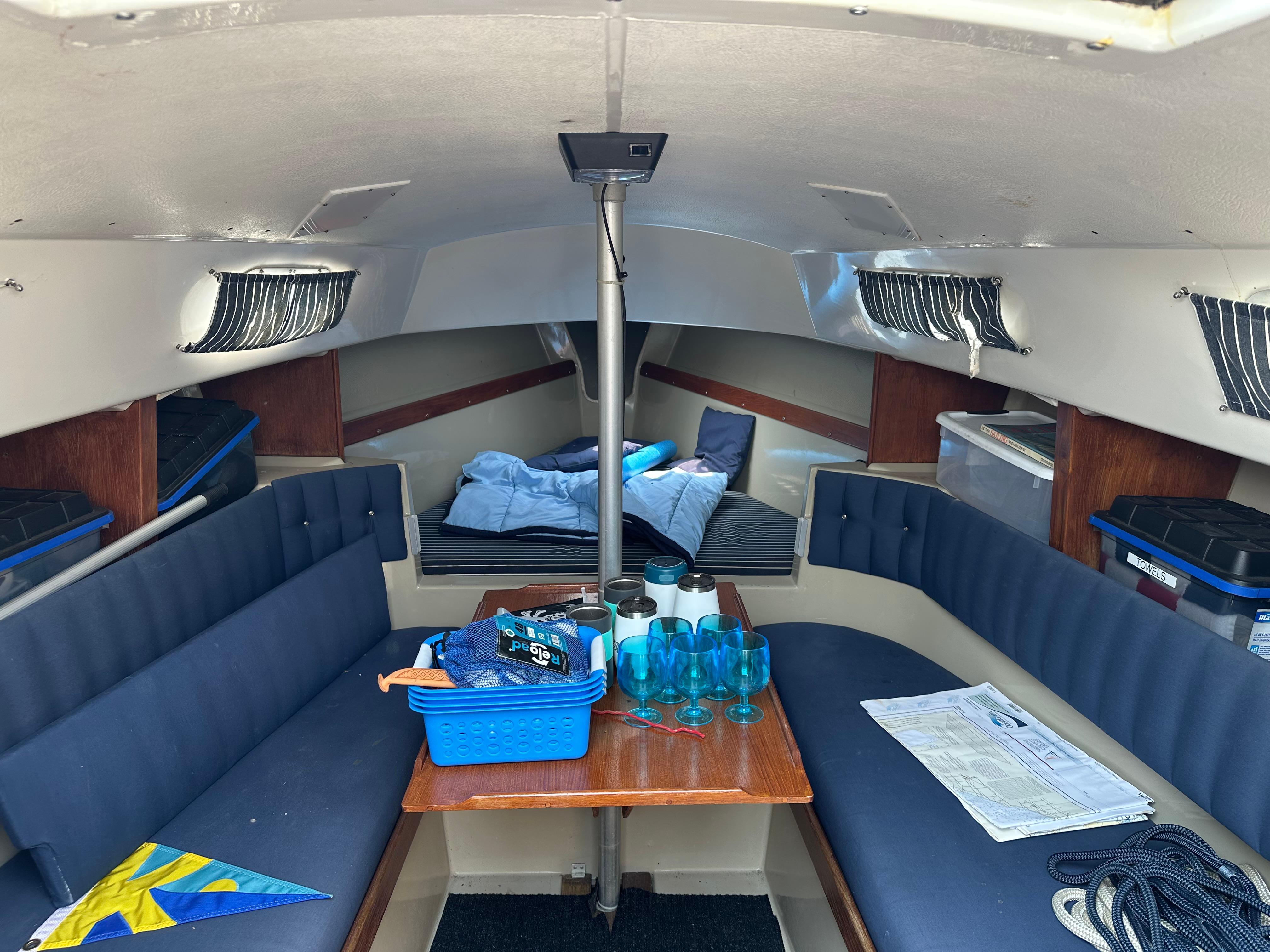 C&C 24ft Interior of a 1978 C&C 24ft sailboat with seating, table, and nautical items.
